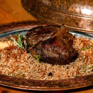 A sumptuous lamb shank served on a bed of aromatic basmati rice with herbs.